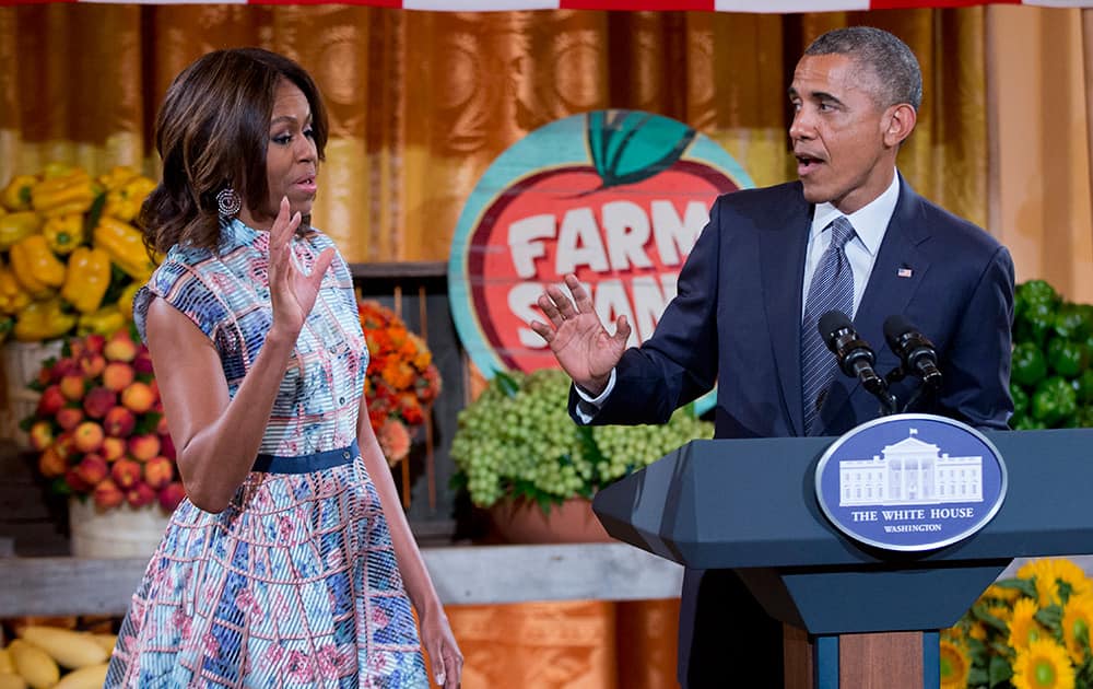 President Barack Obama turns to first lady Michelle Obama, the host of the `Kids State Dinner` in the East Room of the White House in Washington.