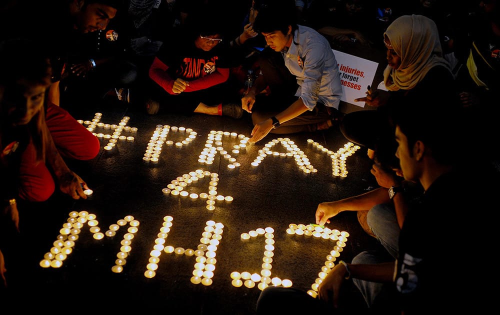 People arrange candles to offer prayers for the victims of the Malaysia Airlines Flight 17, at a shopping mall in Petaling Jaya, near Kuala Lumpur, Malaysia.