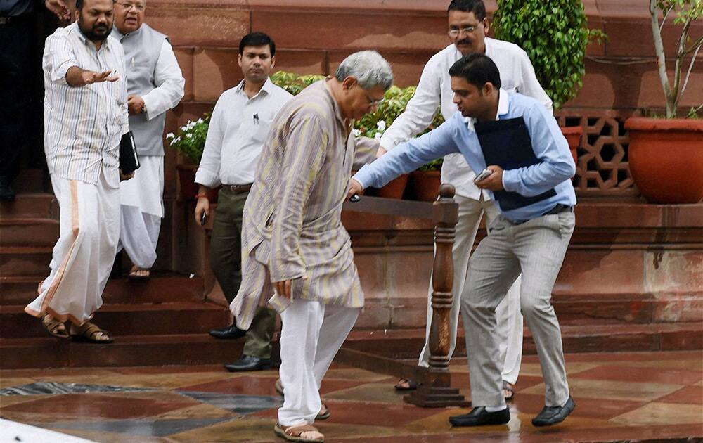 Left leader Sitaram Yechury is helped after he slips at Parliament House in New Delhi.