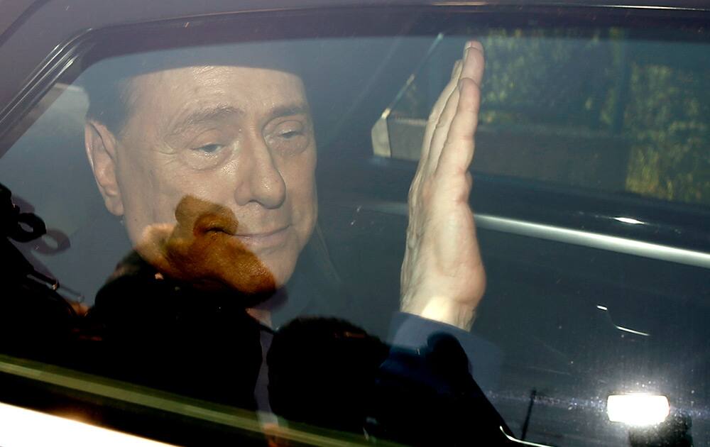 Italy`s former Premier Silvio Berlusconi waves as he leaves the `Sacra Famiglia` institute in Cesano Boscone, Italy. An Italian appeals court has acquitted former Premier Silvio Berlusconi in a sex-for-hire case. 