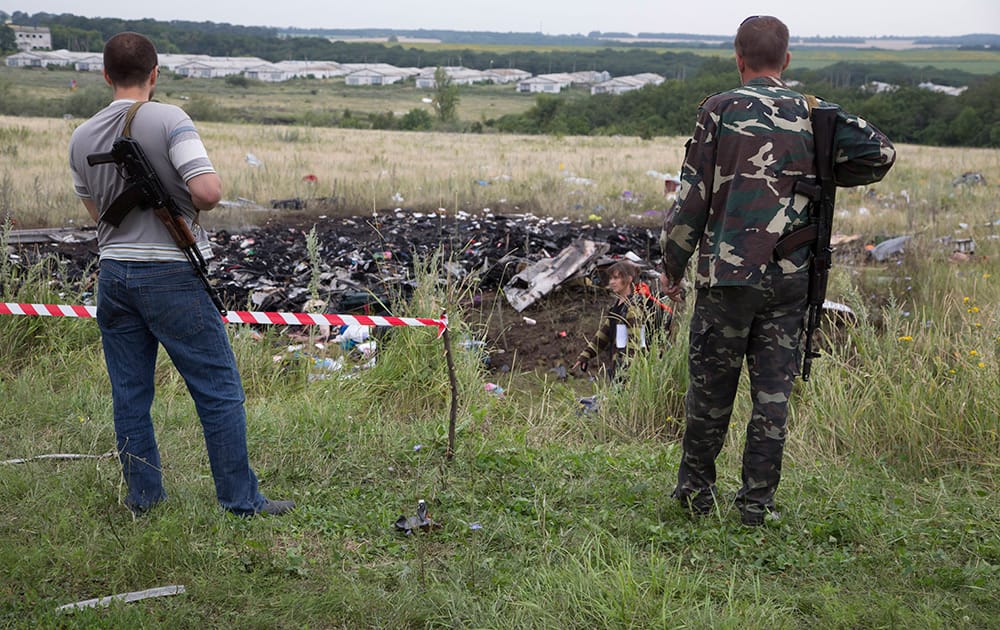 Pro-Russian fighters guard the site of a crashed Malaysia Airlines passenger plane near the village of Rozsypne, Ukraine, eastern Ukraine.