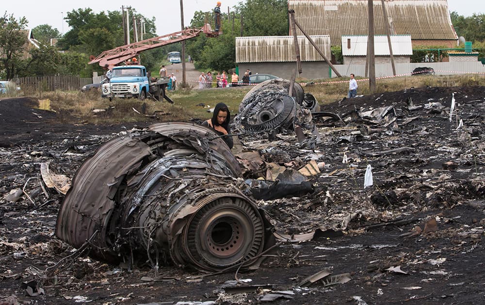 A woman walks at the site of a crashed Malaysia Airlines passenger plane near the village of Rozsypne, eastern Ukraine.