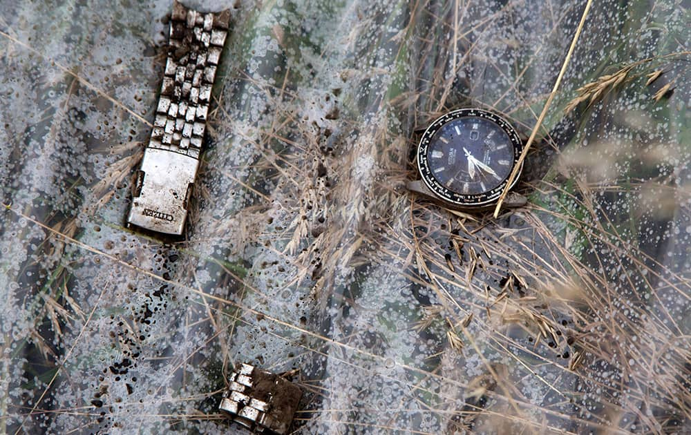 A watch and a part of bracelet lie on a plastic cover at the site of a crashed Malaysia Airlines passenger plane near the village of Rozsypne, Ukraine.