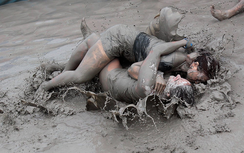 Women wrestle in a mud pool during the Boryeong Mud Festival at Daecheon Beach in Boryeong , South Korea. The 17th annual mud festival features mud wrestling and mud sliding.