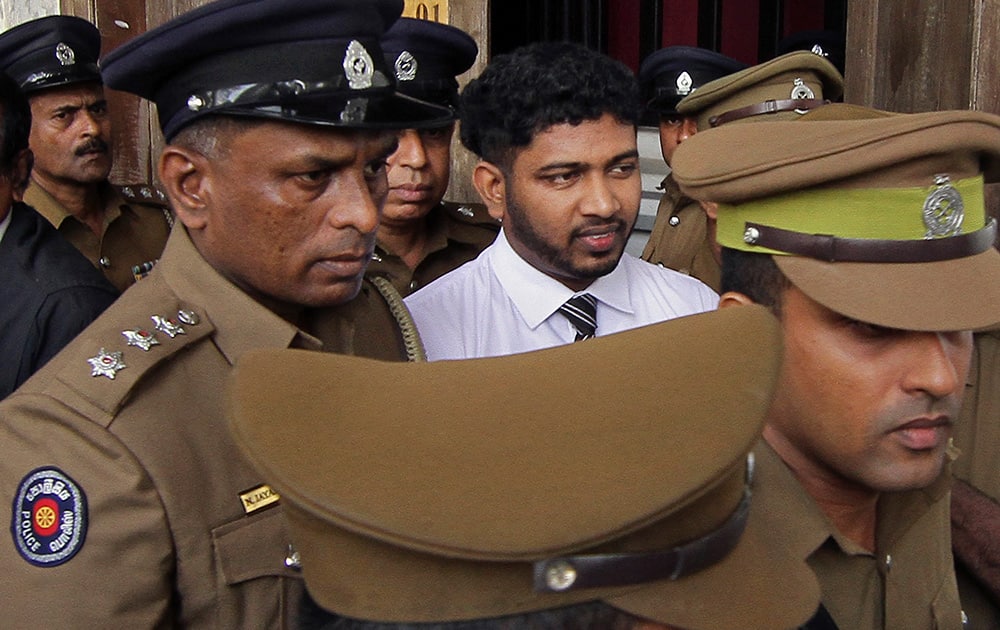 Police officials escort Sampath Vidanapathirana, a ruling party politician, convicted in a murder and rape case at the High Court complex in Colombo. A Sri Lankan court on Friday sentenced Vidanapathirana to 20 years in prison for killing a British tourist Khuram Sheikh and raping his Russian girlfriend more than two years ago.