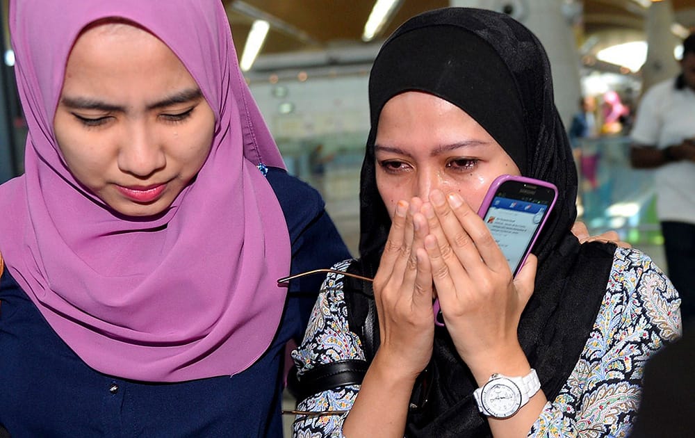 Relatives of passengers aboard the Malaysia Airlines Flight 17 react as they arrive at Kuala Lumpur International Airport in Sepang, Malaysia.