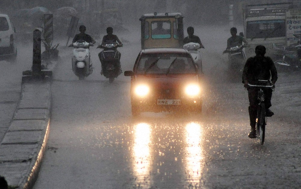 People move at a road amid heavy rains in Beawar.