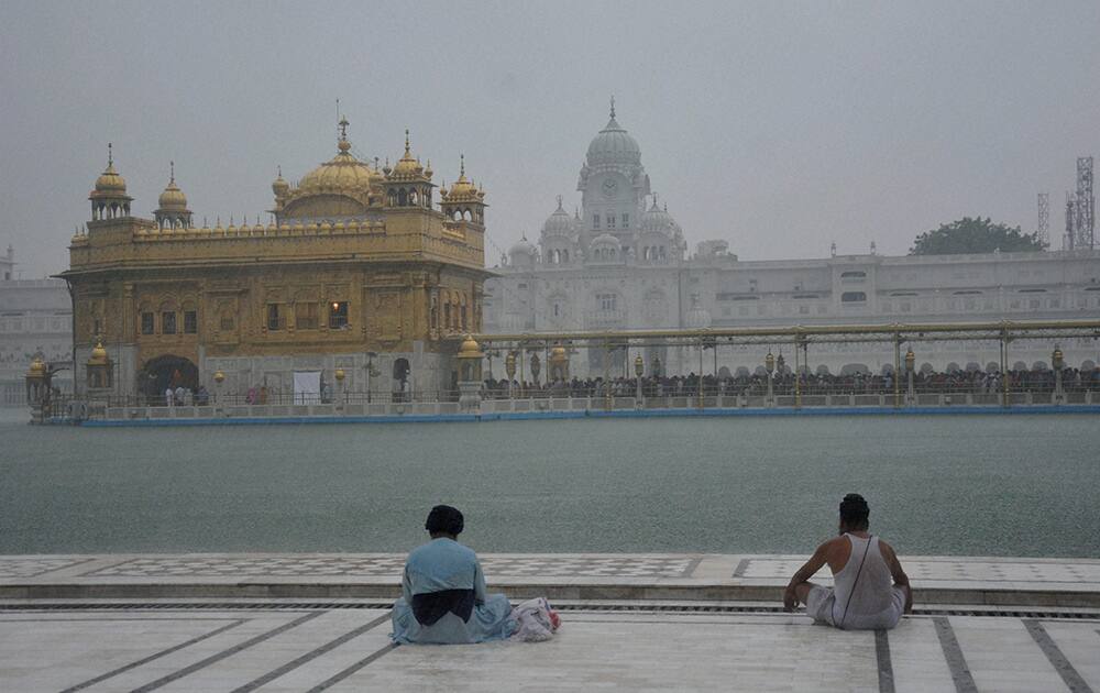 Devotees at Golden Temple amidst rains in Amritsar.