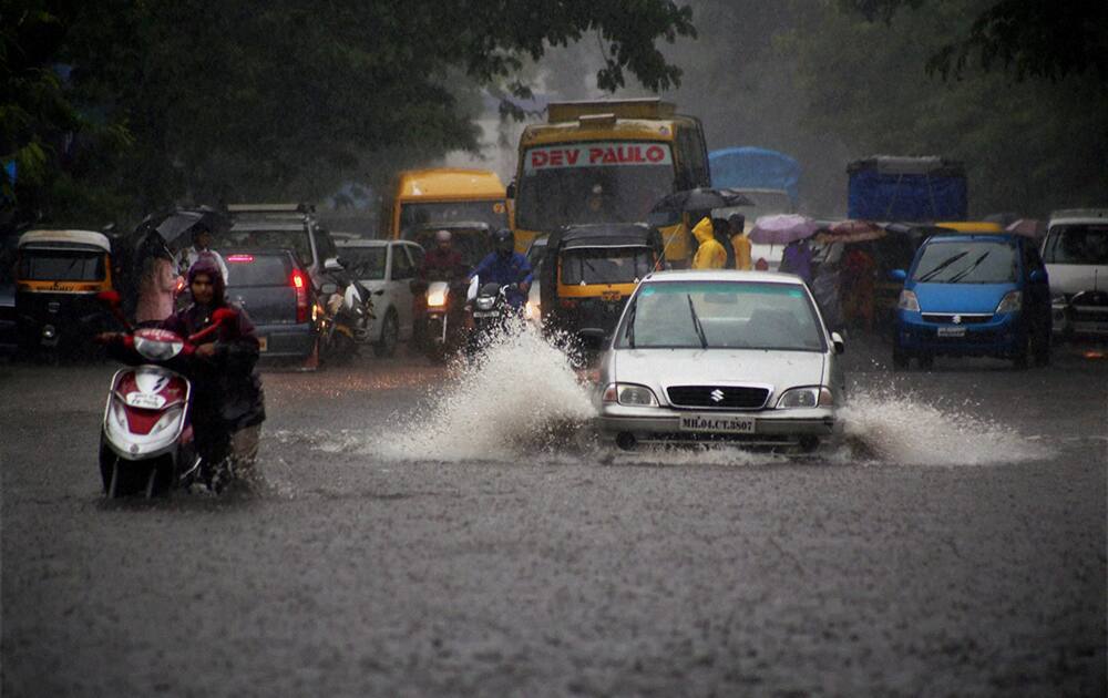 Vehicles wade through a waterlogged street as it rains in Thane, Mumbai.