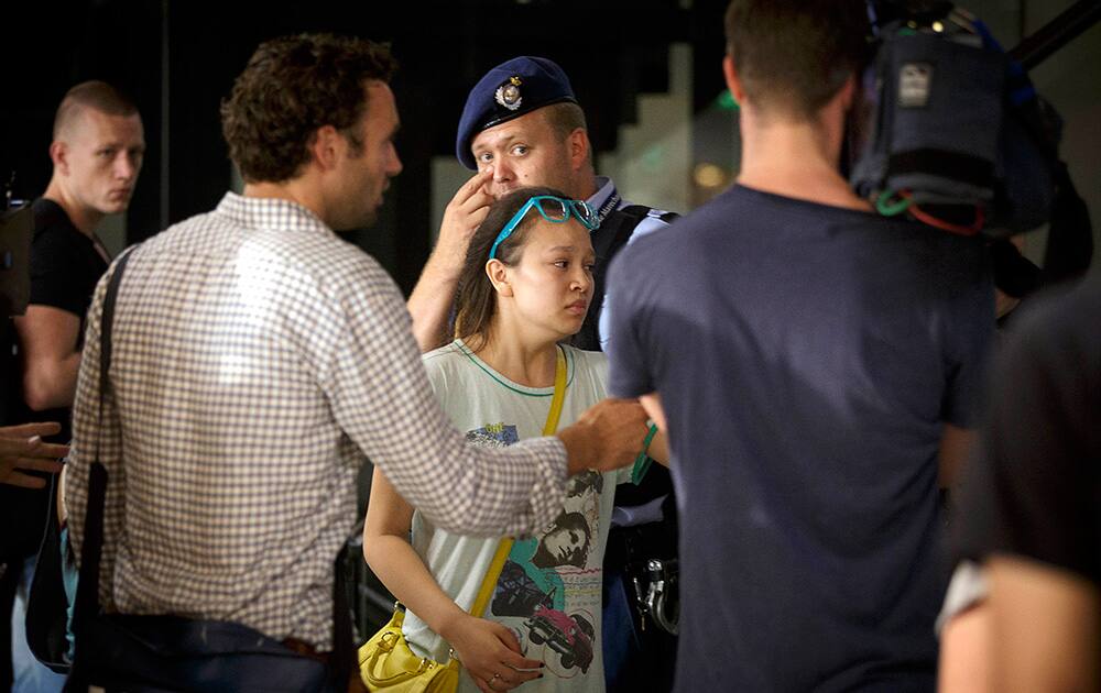 Relatives of passengers on flight MH17 walk past members of the press as they arrive at Schiphol airport in Amsterdam.