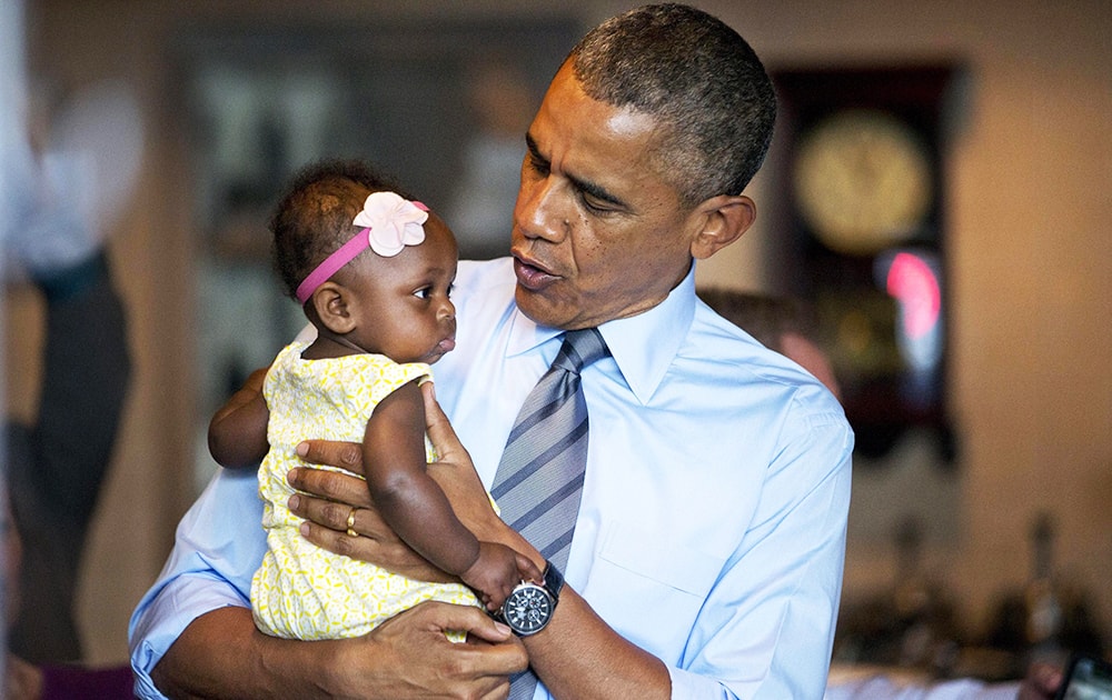 President Barack Obama holds seven-month-old Jaidyn Oates during a stop at the Charcoal Pit in Wilmington, Del.