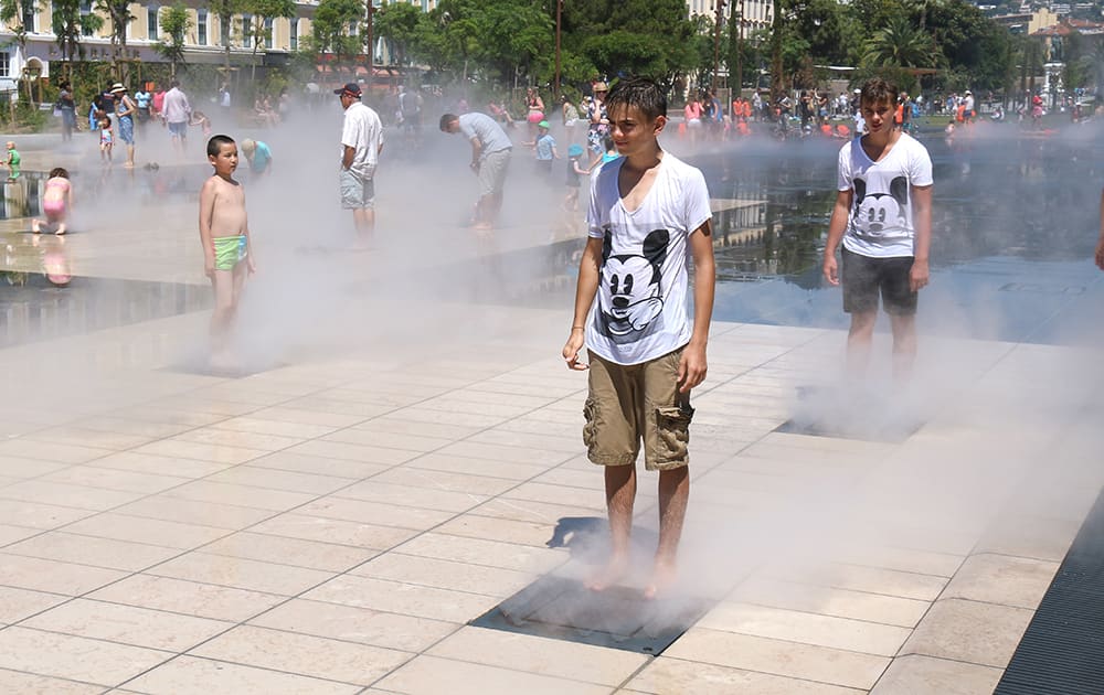 People cool off in the fountains, in Nice, southeastern France.