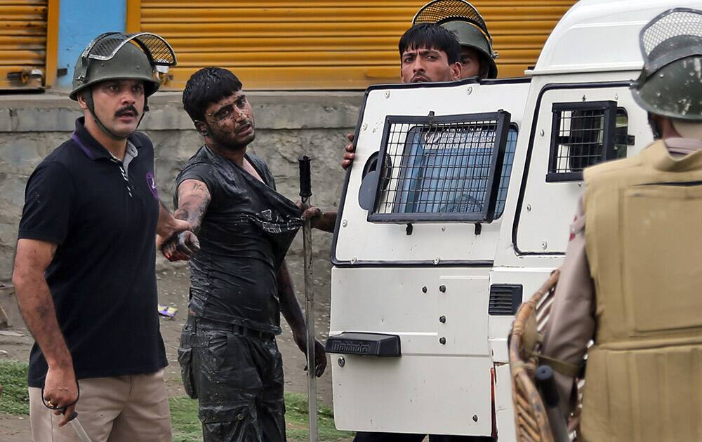 Indian policemen detain a Kashmiri protester in Srinagar, India.