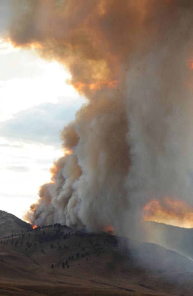 Smoke and fire rise from the Evans fire near the Nevada-California state line north of Reno, Nev.