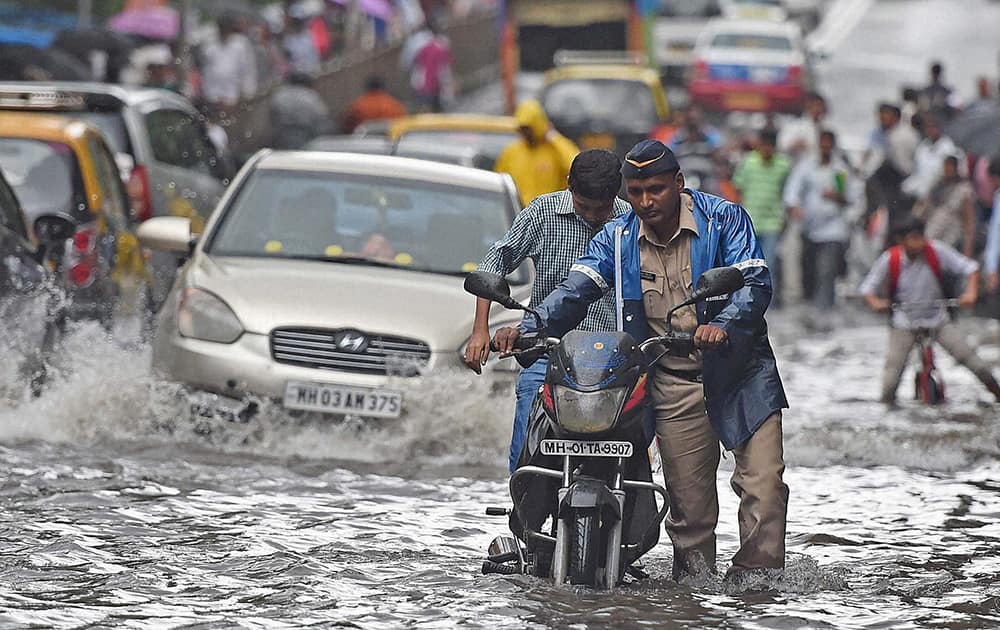 People wade through a flooded street in Mumbai.