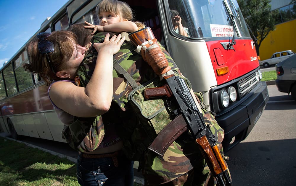 A Donetsk People`s Republic fighter says goodbye to his family departing as refugees to Russia in the city of Donetsk, eastern Ukraine. Ten busloads of Internally Displaced People from the towns of Karlovka, Maryinka and Donetsk left Wednesday morning for the Rostov region in Russia to ask for refugee status there.