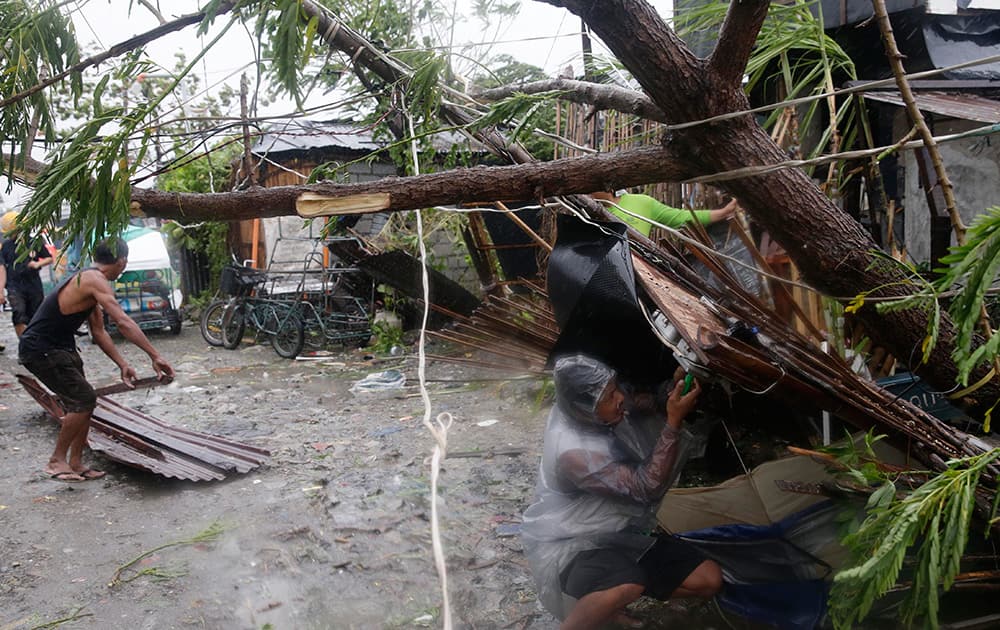 Residents of the slum community of Baseco fix the electrical wiring of their topple house following the onslaught of typhoon Rammasun in Manila, Philippines. 