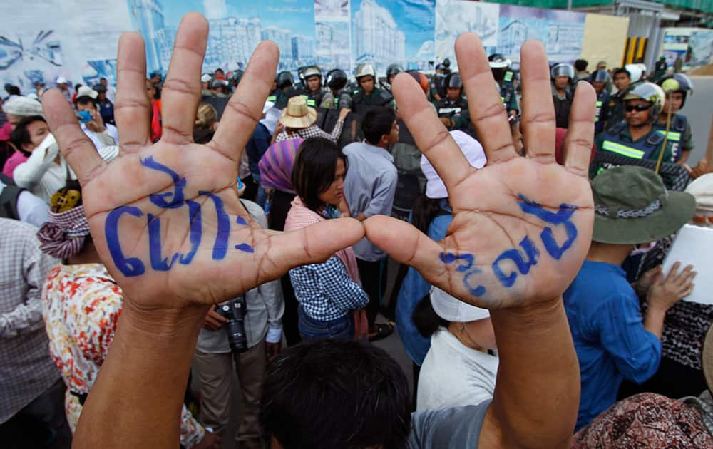 A supporter raises his hands with local letters reading `Release` as the others gather at a blocked main street near Phnom Penh Municipality Court in Phnom Penh, Cambodia.