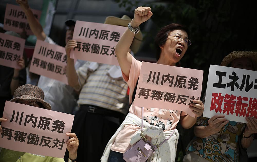 A protester shouts slogans against Sendai nuclear plant which won preliminary approval for meeting stringent post-Fukushima safety requirements, near the Diet building in Tokyo.