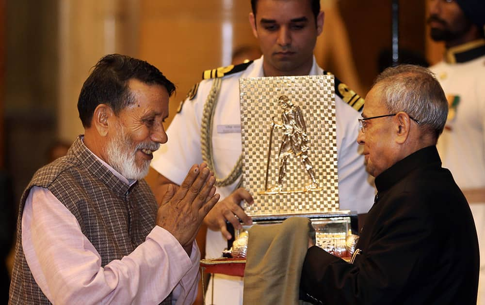 Indian President Pranab Mukherjee, right, confers Gandhi Peace prize to environmentalist Chandi Prasad Bhatt at presidential palace, in New Delhi, India.