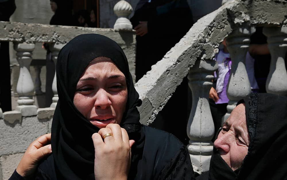  PALESTINIAN MOURNER IS COMFORTED BY ANOTHER OUTSIDE A HOUSE AFTER THE BODIES OF MOUSA ABU MUAMER, 56, AND HIS SON SADDAM, 27, WHO WERE KILLED IN AN OVERNIGHT ISRAELI MISSILE STRIKE AT THEIR HOUSE IN THE OUTSKIRTS OF THE TOWN OF KHAN YOUNIS, SOUTHERN GAZA STRIP, WERE BROUGHT IN DURING THEIR FUNERAL PROCESSION. SADDAM`S WIFE, HANADI, 27, WAS ALSO KILLED IN THE ATTACK.