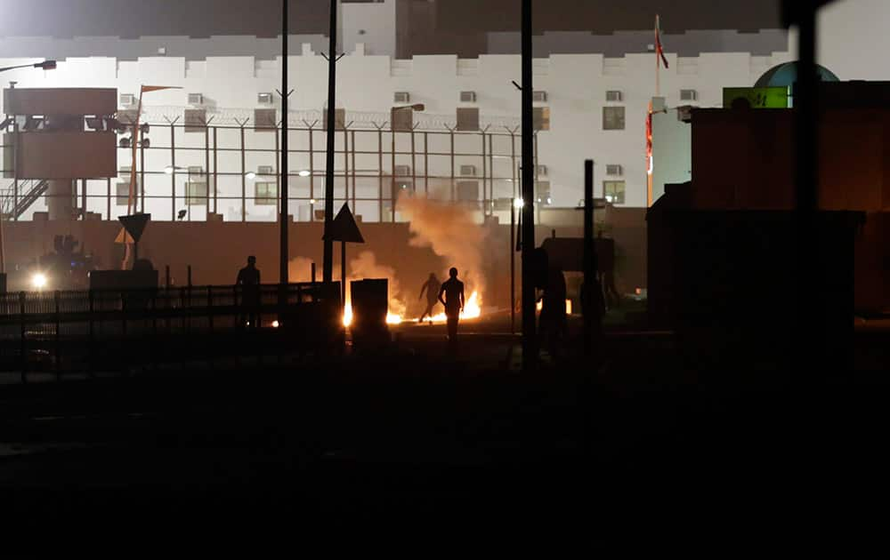 Bahraini anti-government protesters clash with riot police firing tear gas after protesters attacked a municipal building turned police station with petrol bombs in the western village of Karzakan, Bahrain.