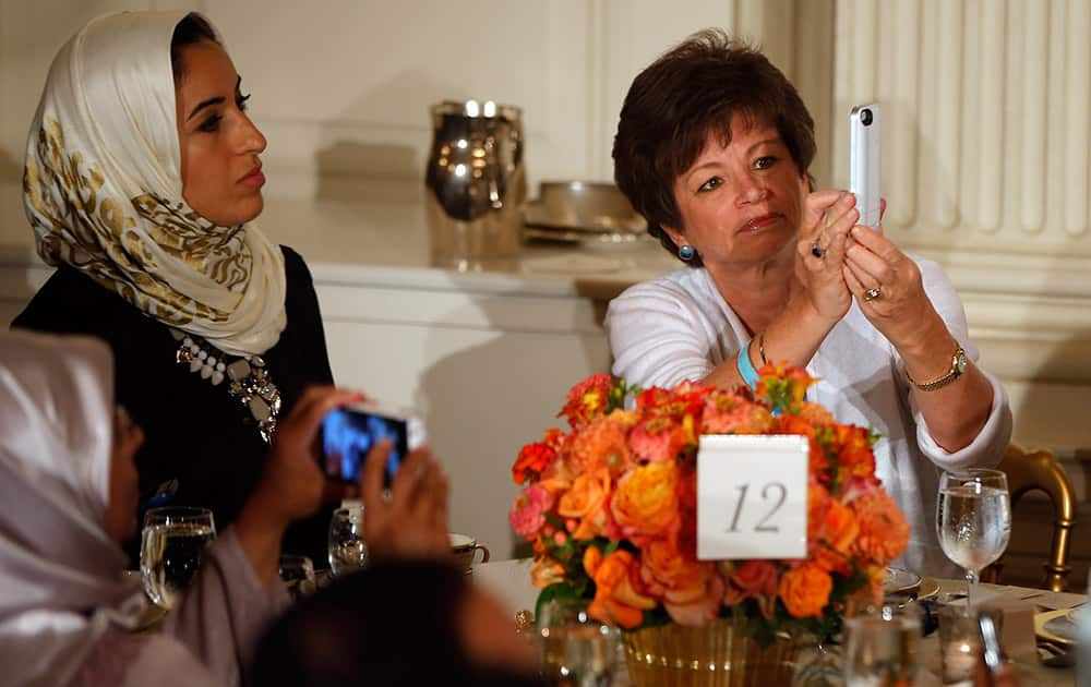 Senior adviser Valerie Jarrett, right, takes a photograph with her iPhone as President Barack Obama speaks as he hosts an Iftar dinner, which celebrates the breaking of fast during the Muslim holy month of Ramadan in the State Dining Room at the White House in Washington.