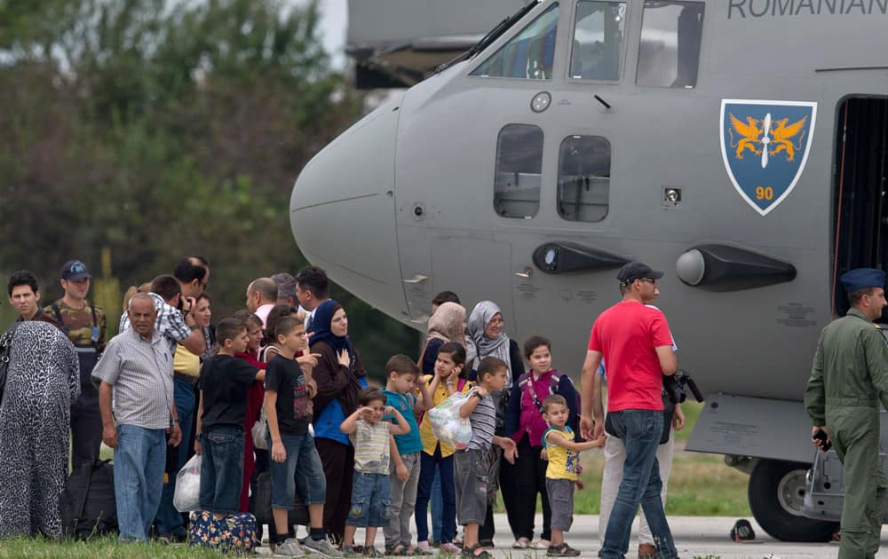 Romanians and of mixed families stand on the tarmac after arriving on a military plane from Gaza, at the Romanian Air Force Base 90, outside Bucharest, Romania.