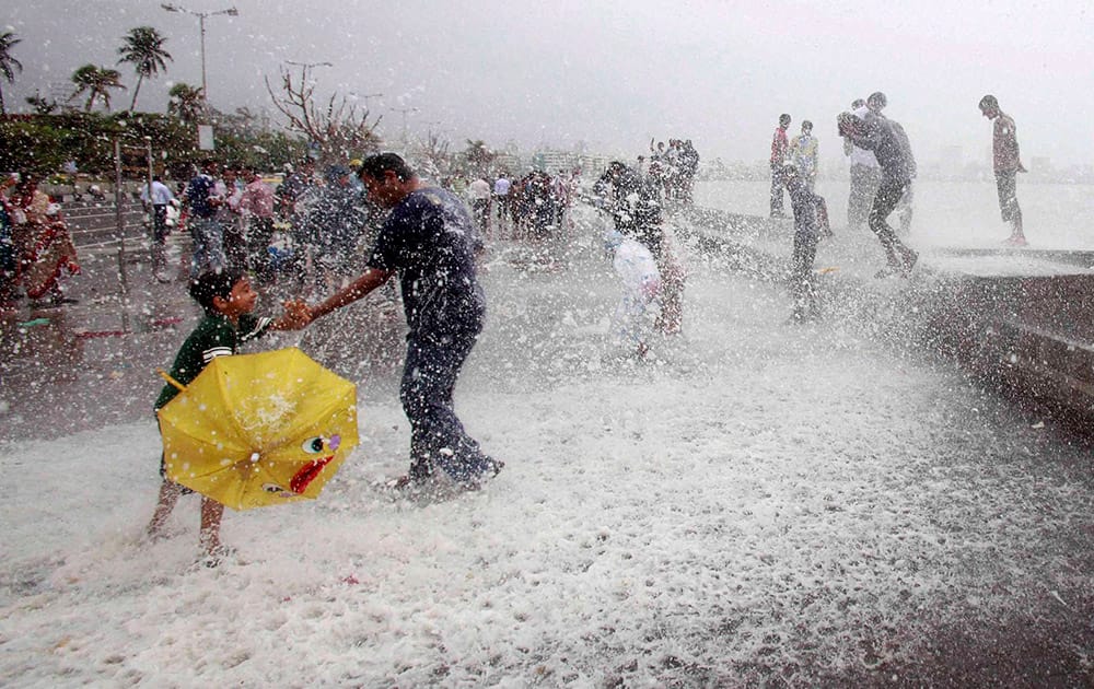 People enjoy high tide at Marine drive in Mumbai.