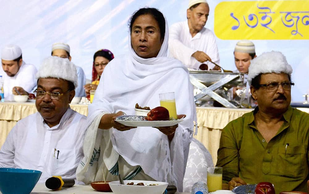 West Bengal Chief Minister Mamata Banerjee joins muslims while breaking their fast at an Iftar in Kolkata.
