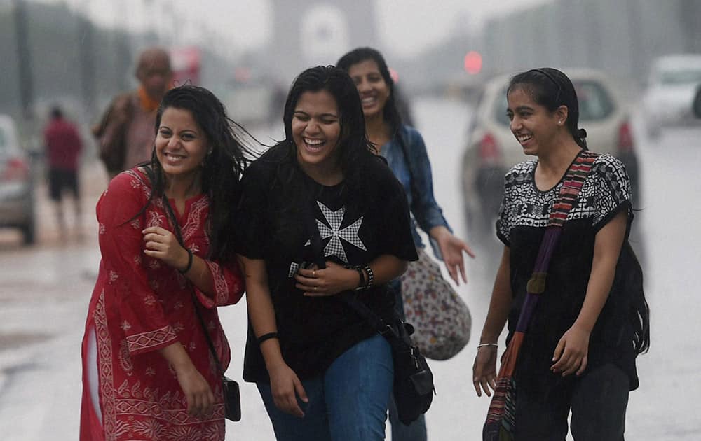 A group of girls revel in the rain at Rajpath in New Delhi.