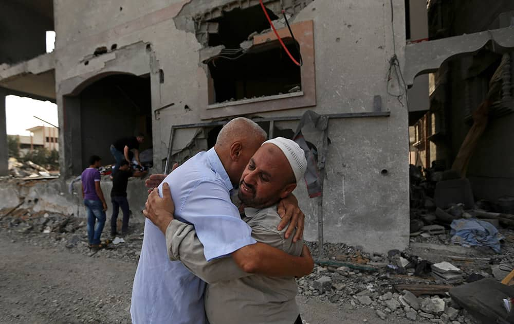 Palestinians give greetings in front of the damaged house of Gaza`s police chief Taysir al-Batsh after it was hit by an Israeli missile strike in Gaza City.