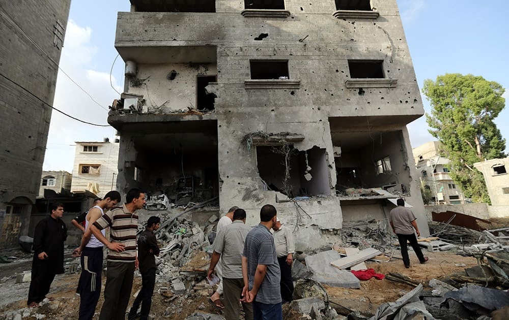 Palestinians gather outside the damaged house of Gaza`s police chief Taysir al-Batsh after it was hit by an Israeli missile strike in Gaza City.