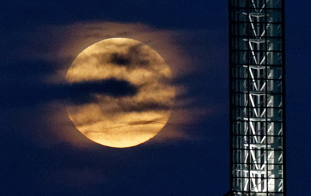 A super moon rises over the Oregon Convention Center in Portland, Ore.