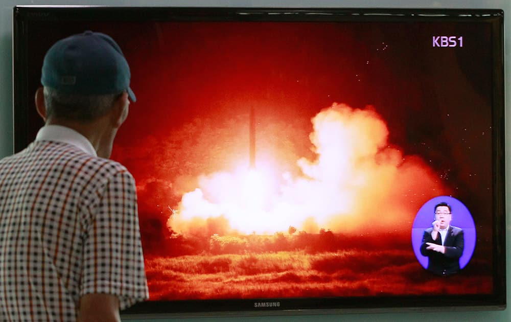 A man watches a TV news program showing a file picture of a missile launch conducted by North Korea, at Seoul Railway Station in Seoul, South Korea.