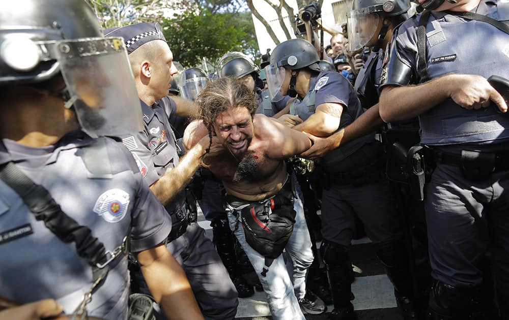 A protester is detained by police during a demonstration by people demanding better public services and against the money spent on the World Cup soccer tournament in Sao Paulo, Brazil.