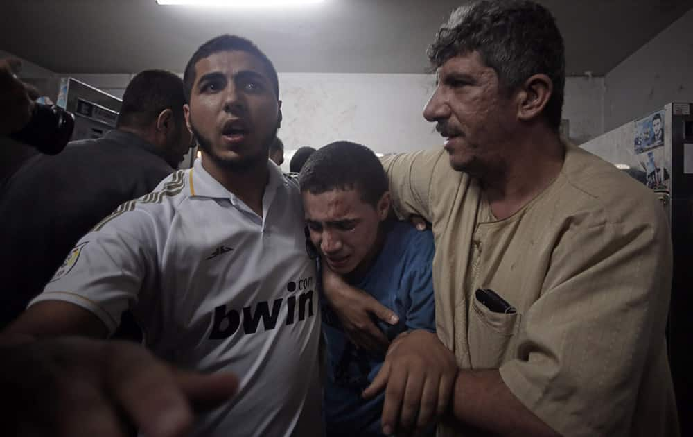 Palestinians mourn their relatives in the morgue of the Shifa hospital in Gaza City. Over a dozen Palestinians were killed in an Israeli strike on a house, hospital officials said.