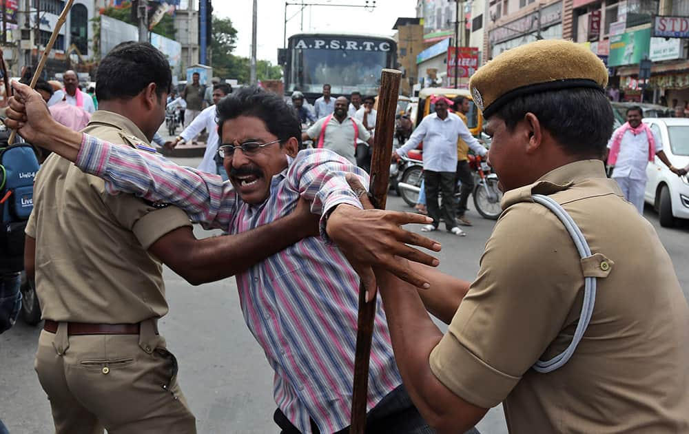 Indian policemen detain an activists protesting against the ordinance on Polavaram project in Hyderabad.