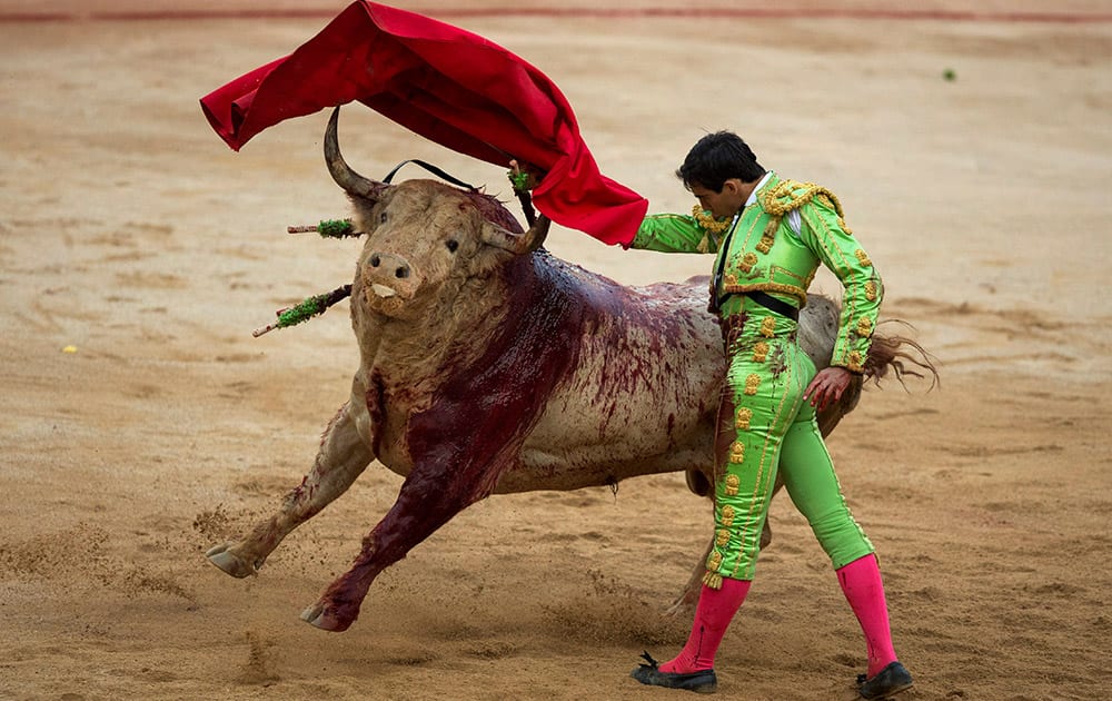 Spanish bullfighter Jimenez Forte performs with a Fuente Ymbro ranch fighting bull during a bullfight of the San Fermin festival in Pamplona, Spain.