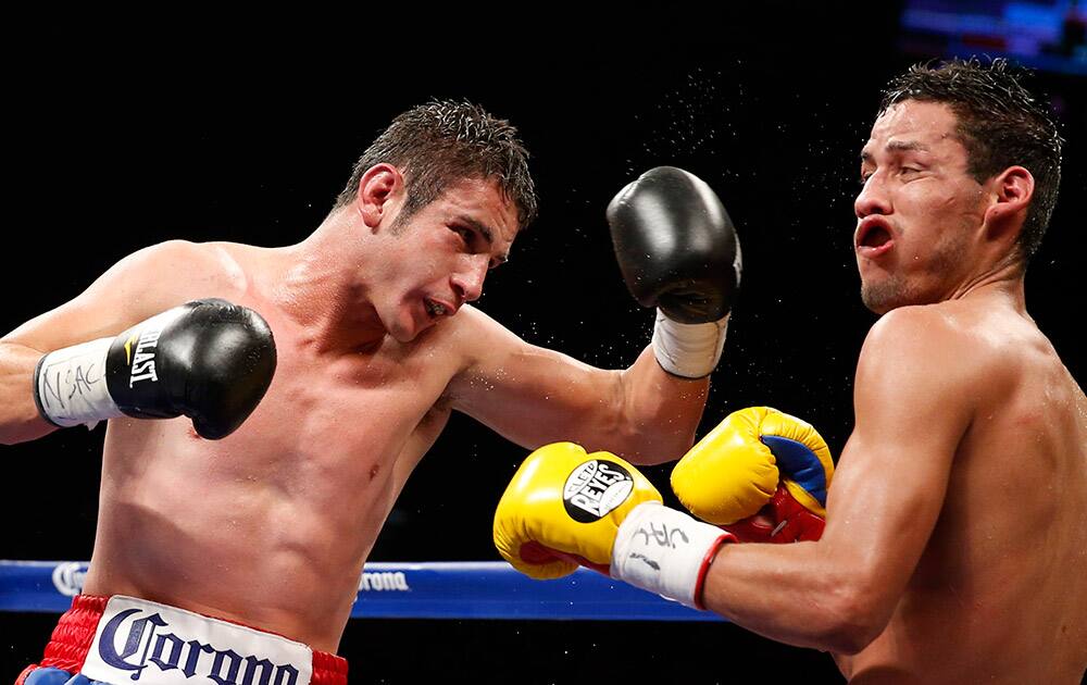 Mauricio Herrera, left, lands a punch on Johan Perez during their WBA super lightweight title fight, in Las Vegas. 