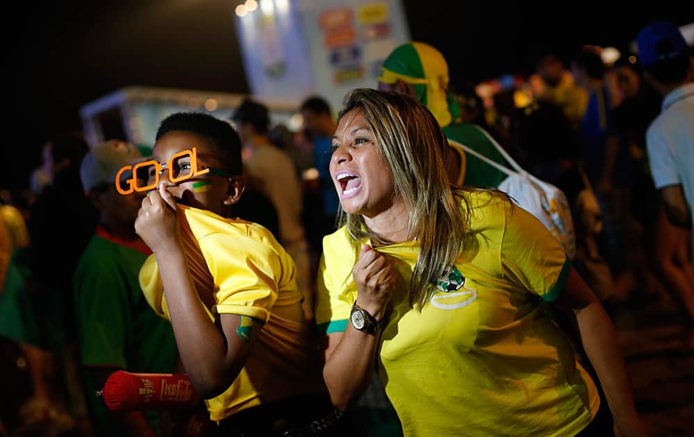 FANS OF THE BRAZIL NATIONAL SOCCER TEAM CHEER FOR THEIR TEAM IN FRONT A VIDEO CAMERA AFTER A LIVE BROADCAST OF THE WORLD CUP THIRD-PLACE SOCCER MATCH BETWEEN BRAZIL AND THE NETHERLANDS, INSIDE THE FIFA FAN FEST AREA ON COPACABANA BEACH, RIO DE JANEIRO, BRAZIL.