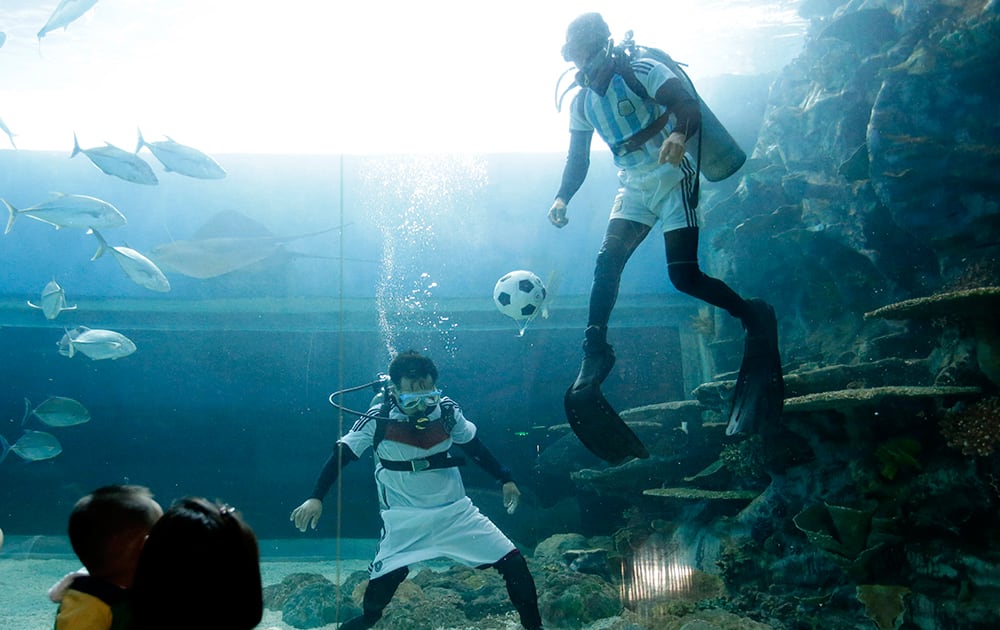 Visitors watch as divers, wearing jerseys of Germany and Argentina, top right, battle for the ball during an underwater friendly match at the Manila Ocean Park, one of Asia`s largest oceanarium, in support of the World Cup final in Brazil.