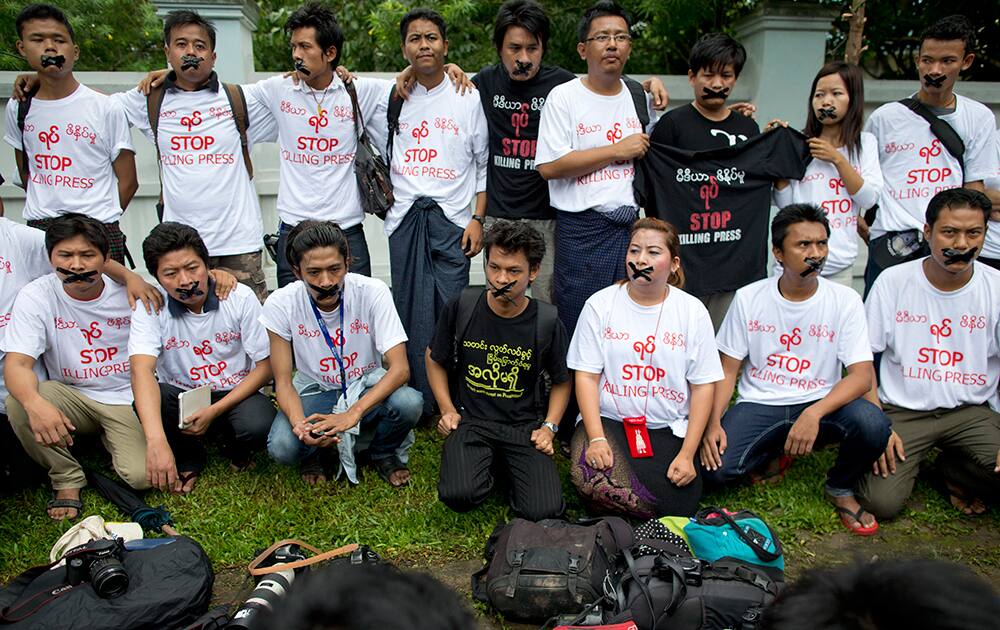 Myanmar journalists with their mouths sealed with tape, symbolizing the government`s recent crackdown on the media, protest outside Myanmar Peace Center where Myanmar President Thein Sein attends a meeting in Yangon, Myanmar.