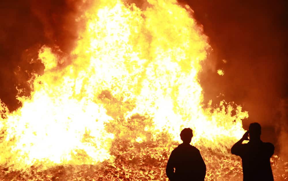 Tourists take a picture at a loyalist bonfire in the Sandy Row area of South Belfast, Northern Ireland.