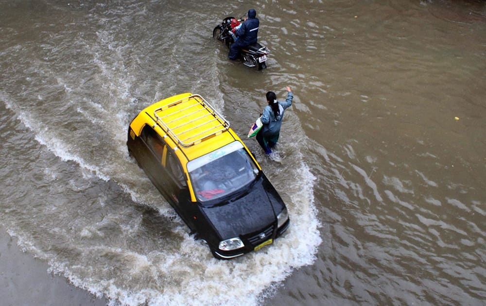 A taxi makes its way through a waterlogged street after heavy rains in Mumbai.