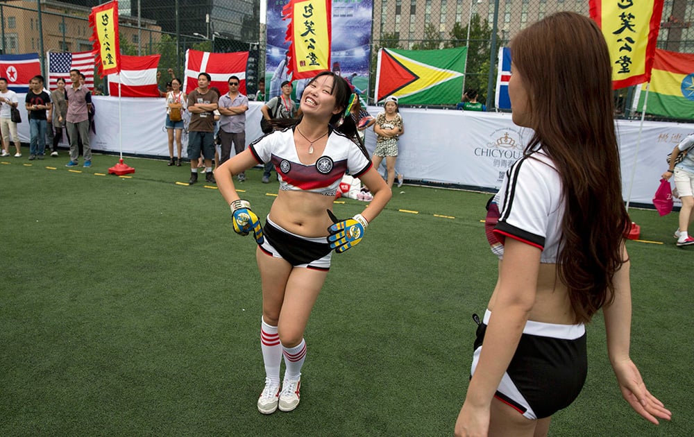 A girl wearing Germany`s colors practice her dance before an event using the World Cup soccer theme to promote an Internet film in Beijing.