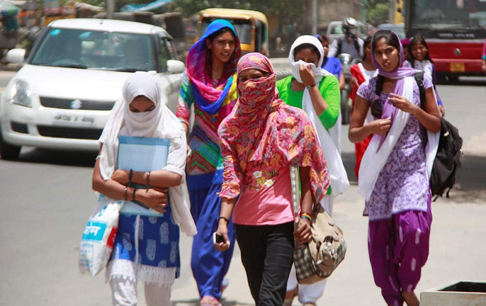 College girls cover their faces to beat the scorching heat in Gurgaon.