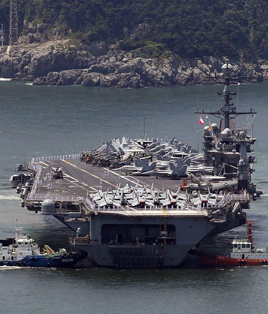 The nuclear-powered aircraft carrier USS George Washington is escorted into a navy port in Busan.