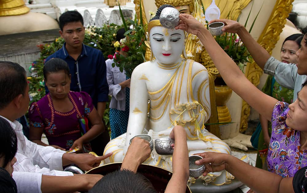 Myanmar Buddhist devotees pour water on a Buddha statue at Shwedagon Pagoda during the full moon day of Waso, the fourth month of Myanmar calendar and the beginning of Buddhist Lent, in Yangon, Myanmar.