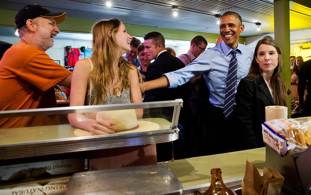 President Barack Obama jokes with patrons as he orders barbecue for himself and the people in the front of the line at Franklin Barbecue in Austin, Texas.